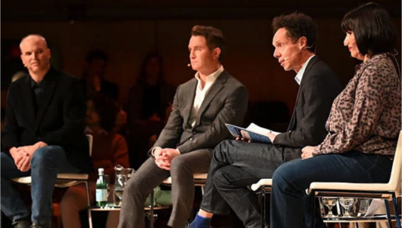 four Munk debater on a stage