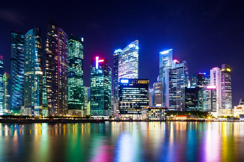 Buildings at night across water.