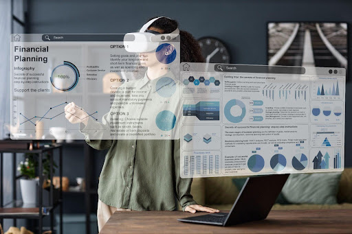 Person wearing VR googles working with display screens.
