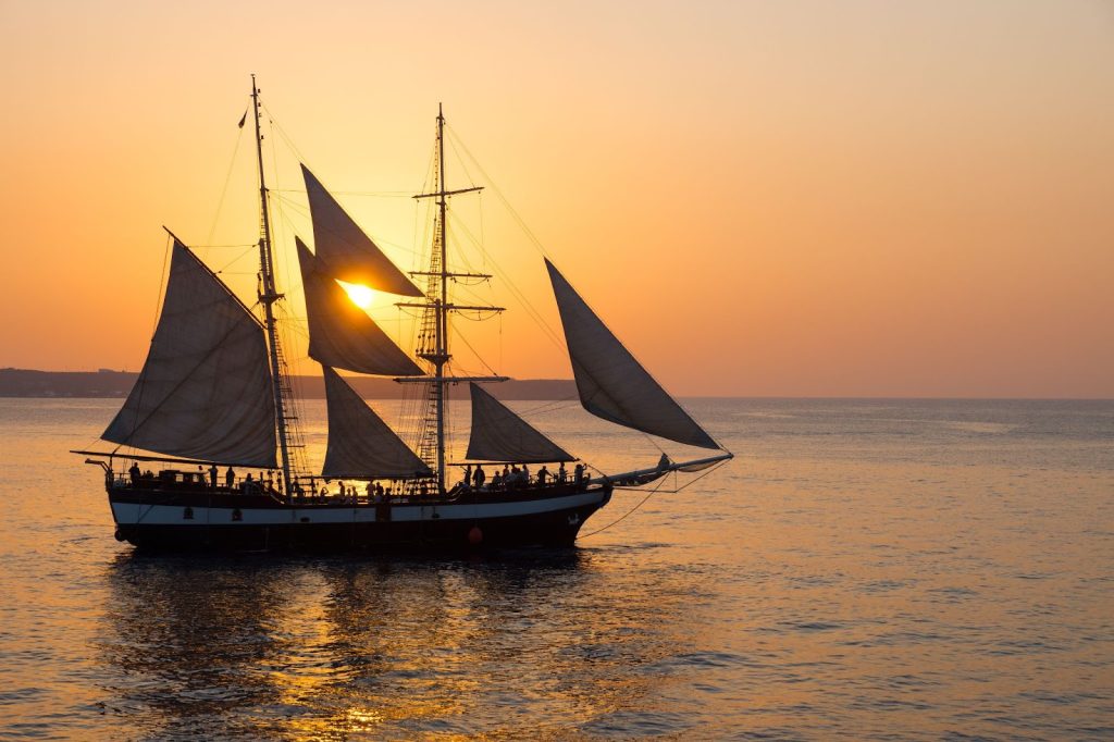 Tall ship sailing during sunset