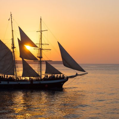 Tall ship sailing during sunset