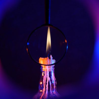 lit candle surrounded by colorful aura