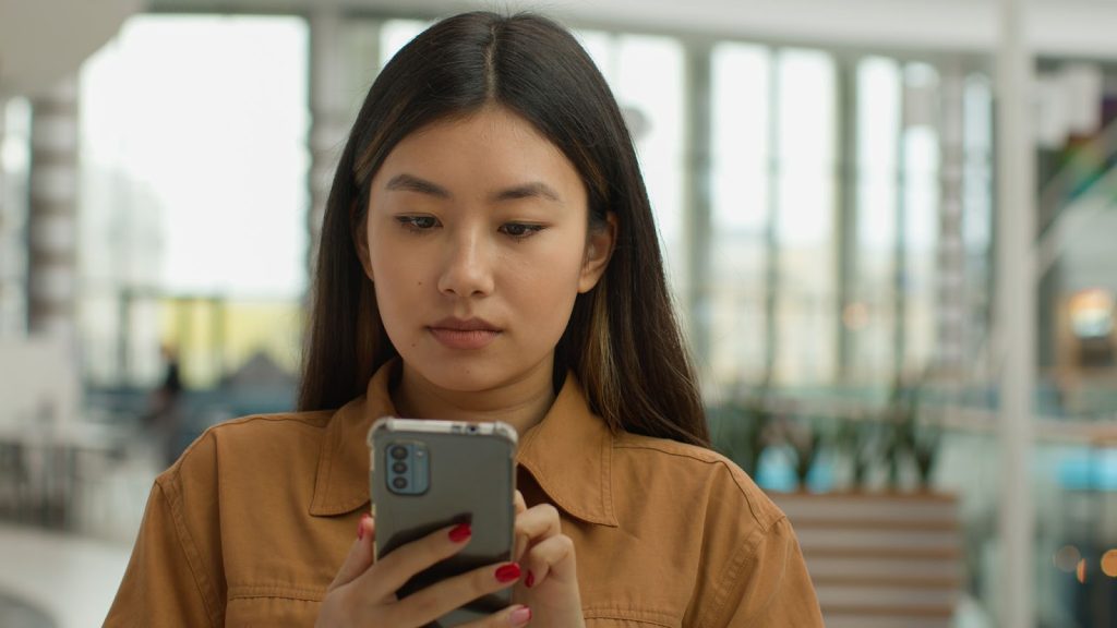 Young woman looking at her mobile phone