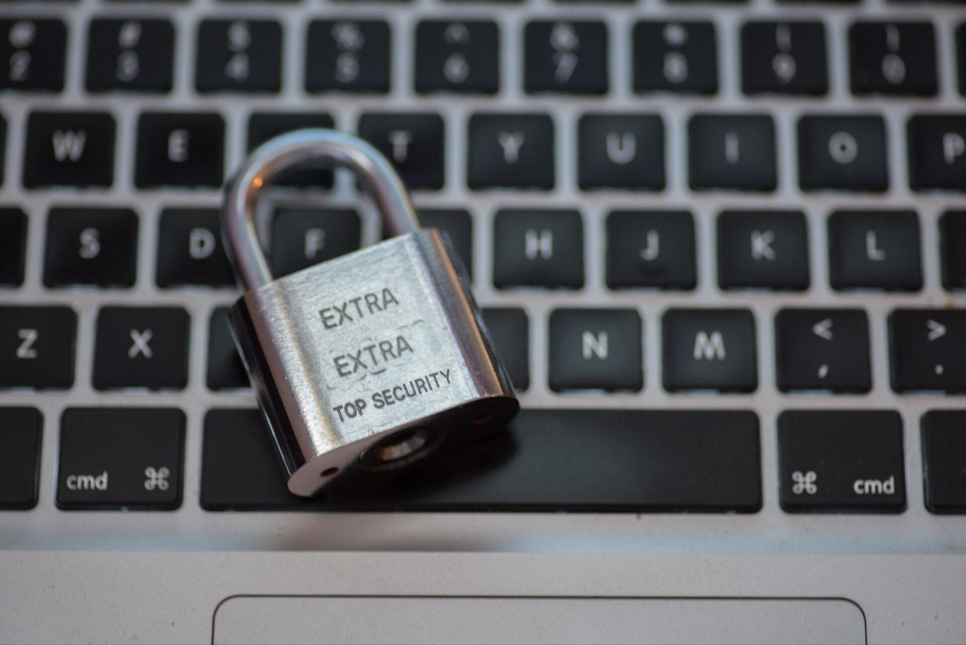 Padlock with words on it laying on a computer keyboard.